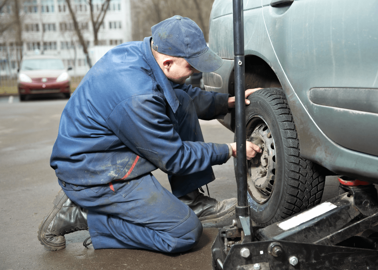 Technician Performing Tire Rotation on Car